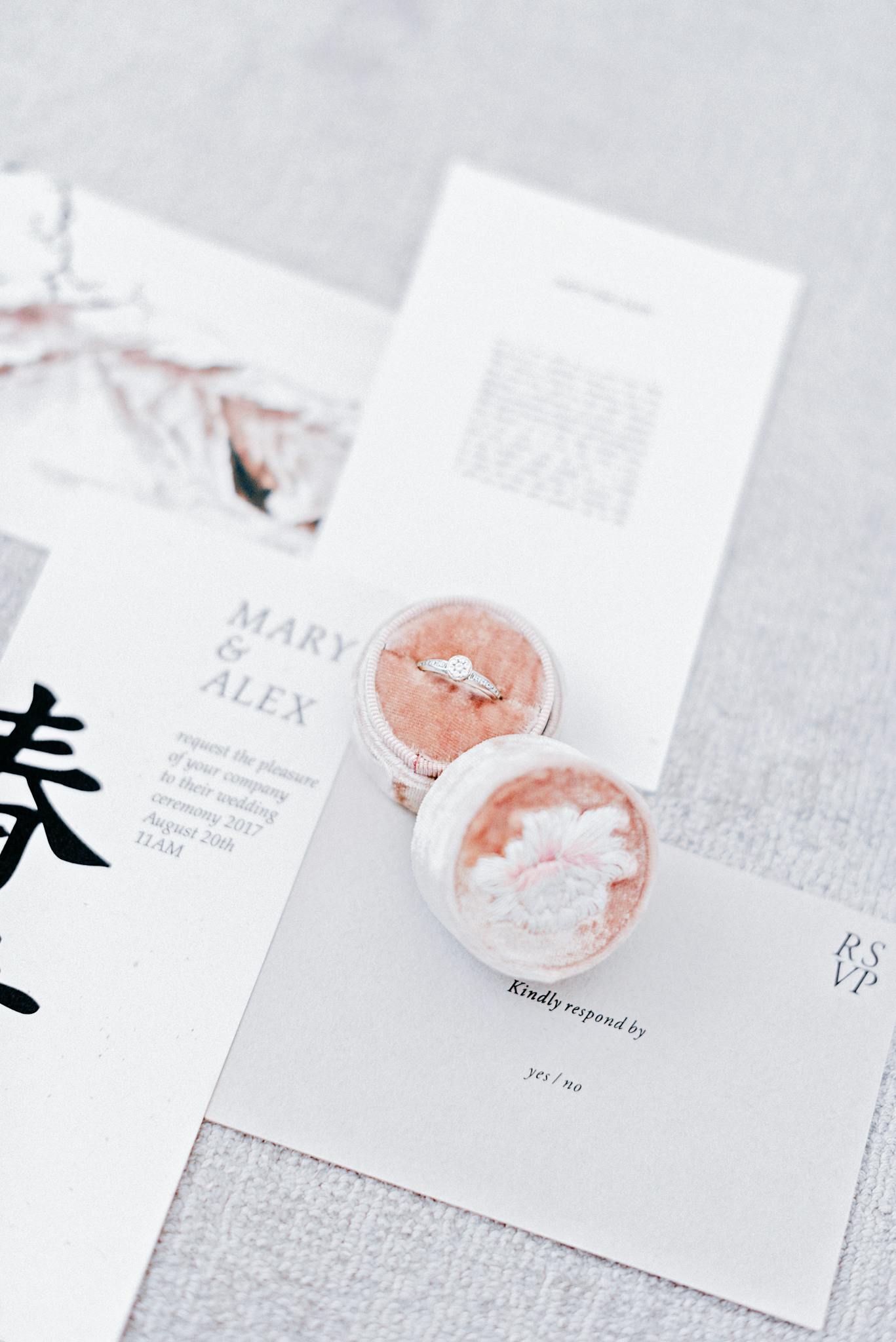 Close-up of a wedding invitation with a diamond ring in a velvet box, perfect for invitations.